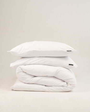 Crisp white duvet cover set in Scandinavian White, breathable jersey-knit cotton by The T‑Shirt Bed Co.